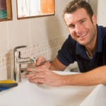 What are the risks facing the business you want to start? Plumber working on sink smiling